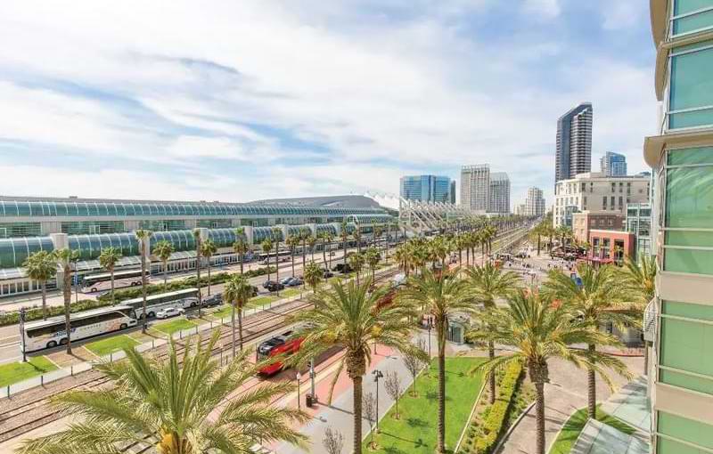 San Diego Convention Center exterior, nearby hotels, Harbor Drive, and palm tree-lined streets